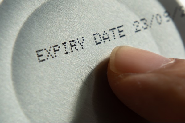 Finger pointing at the expiry date on canned food